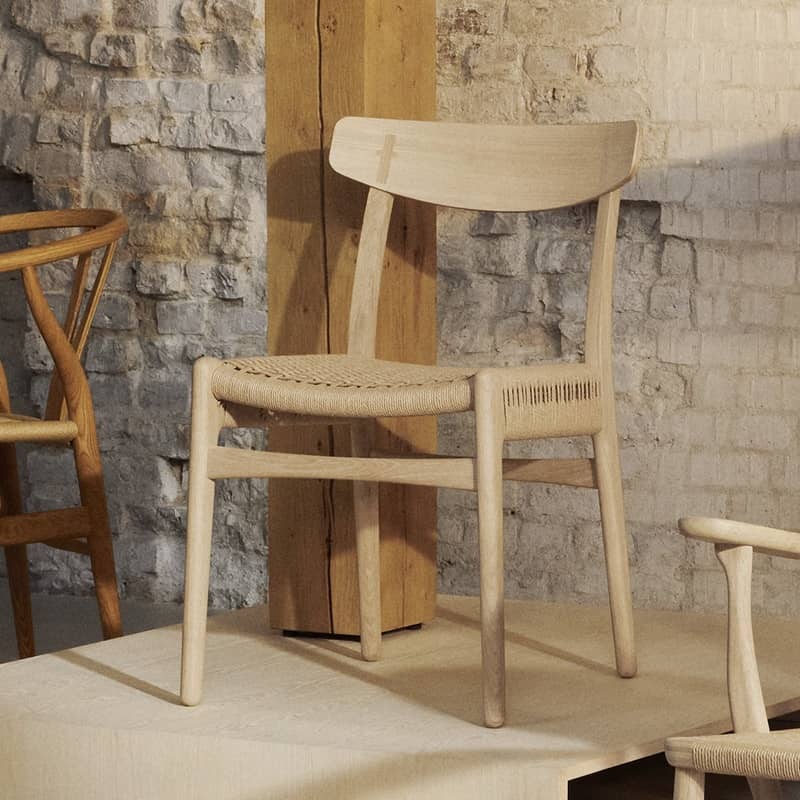 Auf einem kleinen Podest steht ein Stuhl aus hellem Holuz